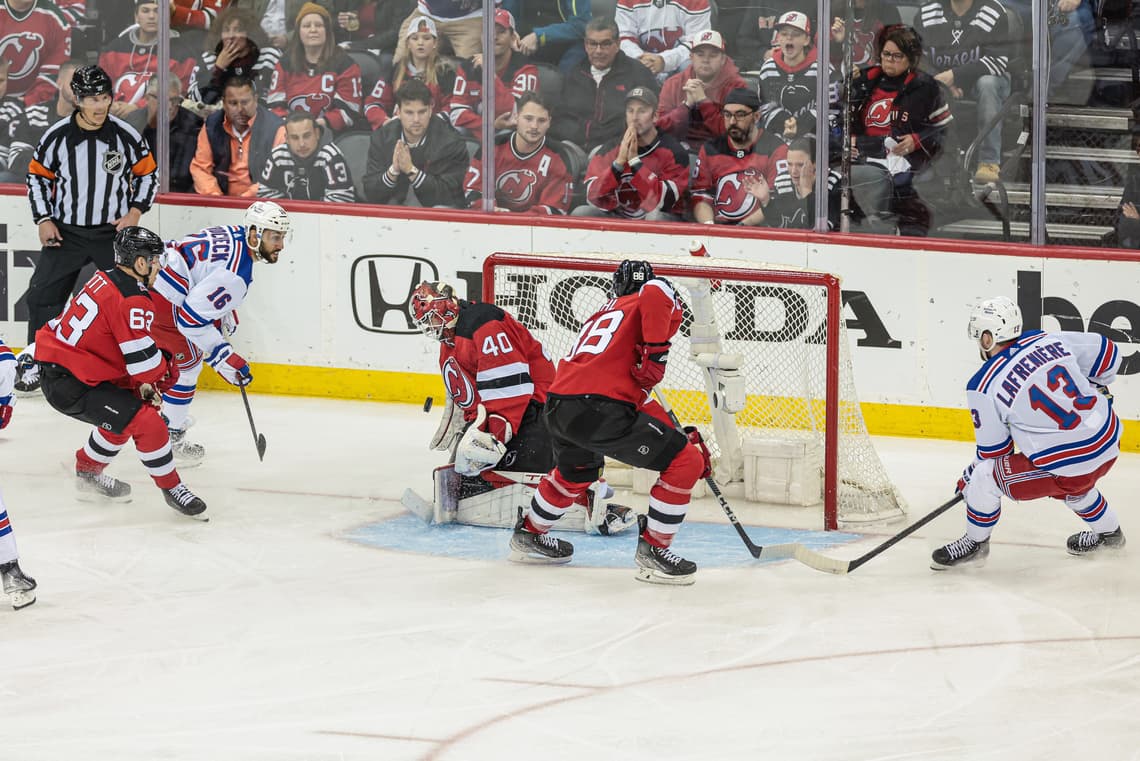 New Jersey Devils player shoots at New York Rangers goalie during playoff game