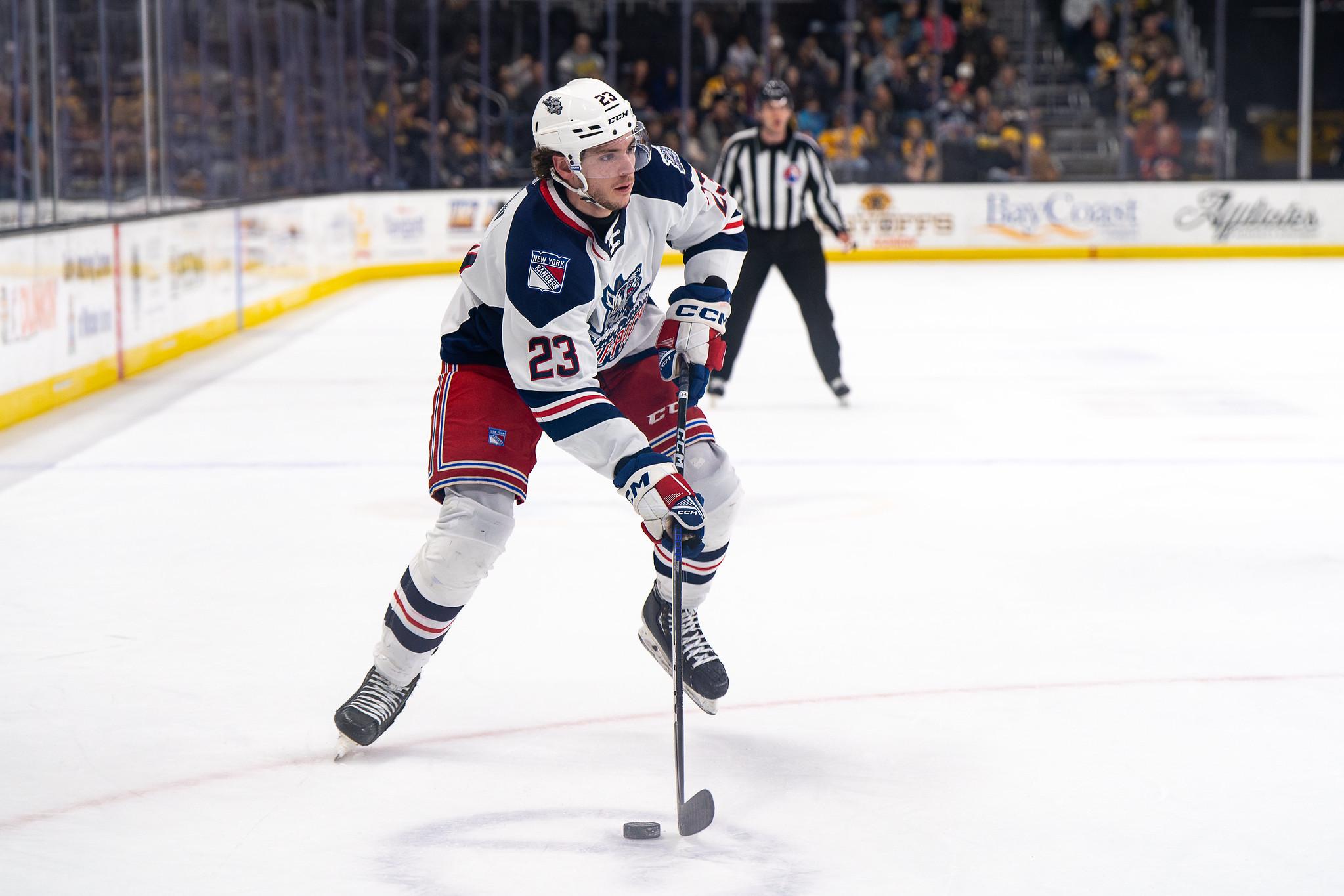 Victor Mancini skating with the puck during an NHL game in Rangers uniform number 23