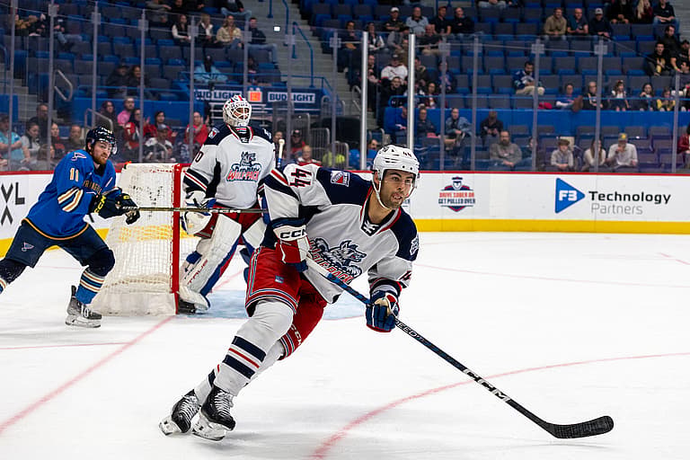 Hartford Wolf Pack player skating with puck during game against St. Louis Blues affiliate
