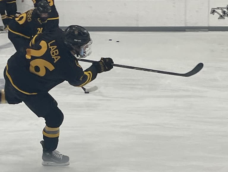 Noah Laba skating with hockey stick during Colorado College game