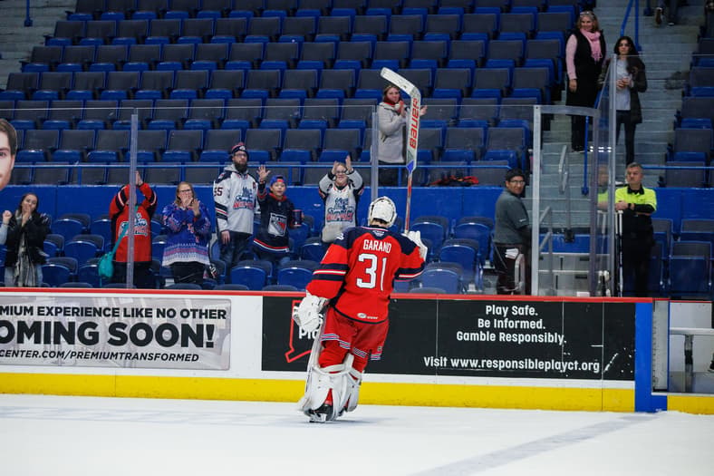 Dylan Garand celebrates after a Wolf Pack victory, acknowledging fans in the stands