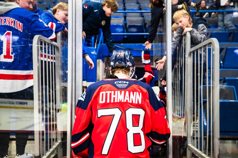 Hockey player Othmann walking through tunnel with fans watching from stands