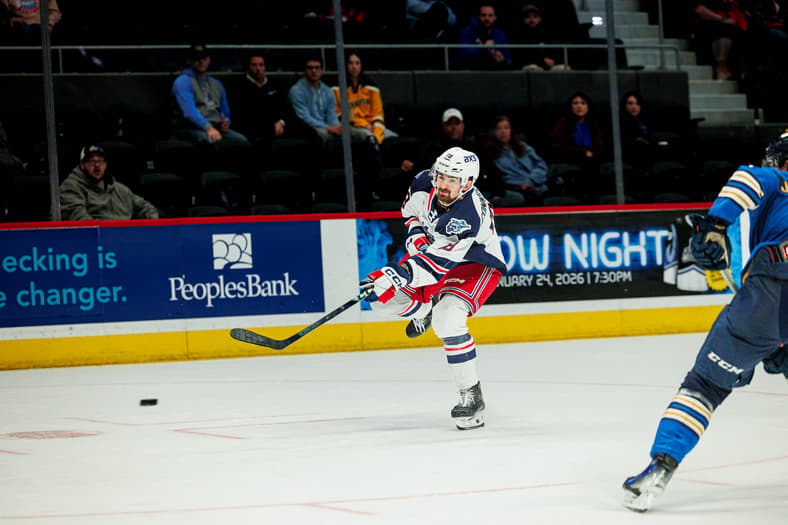 Hockey player in Rangers uniform passing puck during AHL game at Hartford arena