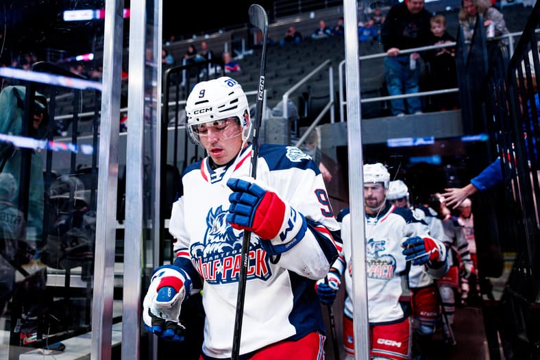 Hockey player wearing number 9 Rappack jersey entering rink during game