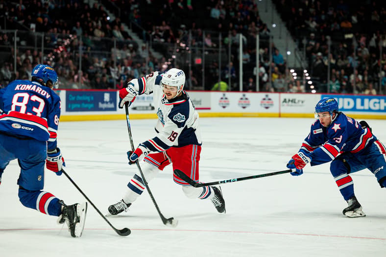 Brendan Brisson skating with the puck against New York Rangers defenders