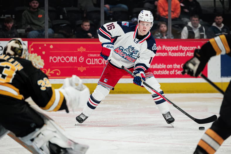 Player #16 in Hartford Wolf Pack uniform controls puck during game against Boston Bruins