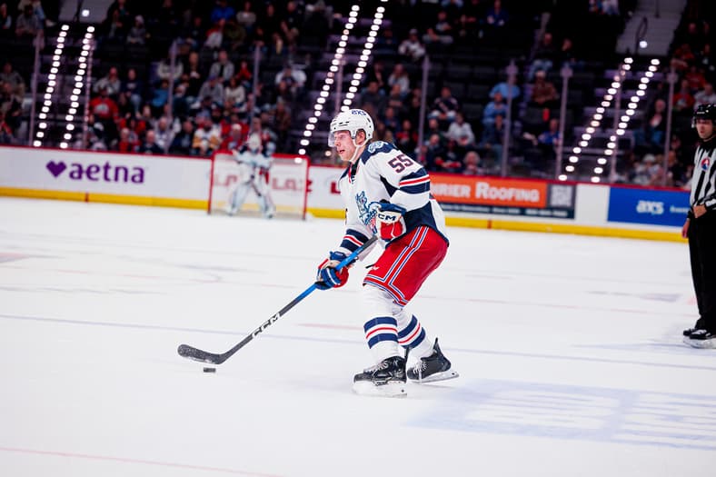 Player in Rangers white and red jersey controls puck during game at Madison Square Garden
