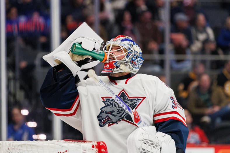 Goaltender in Hartford Wolf Pack uniform taking a drink during game