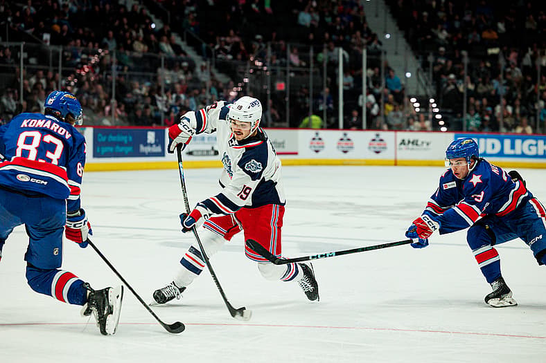 Brendan Brisson skating with the puck against New York Rangers defenders