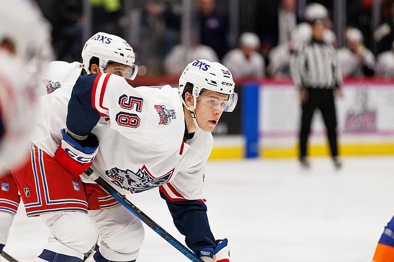 Hockey player wearing Hartford Wolf Pack uniform skating during game