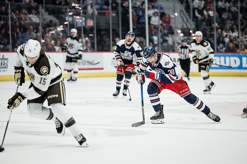 Player #38 in Rangers jersey controls puck during Hartford Wolf Pack game against Winnipeg Jets.