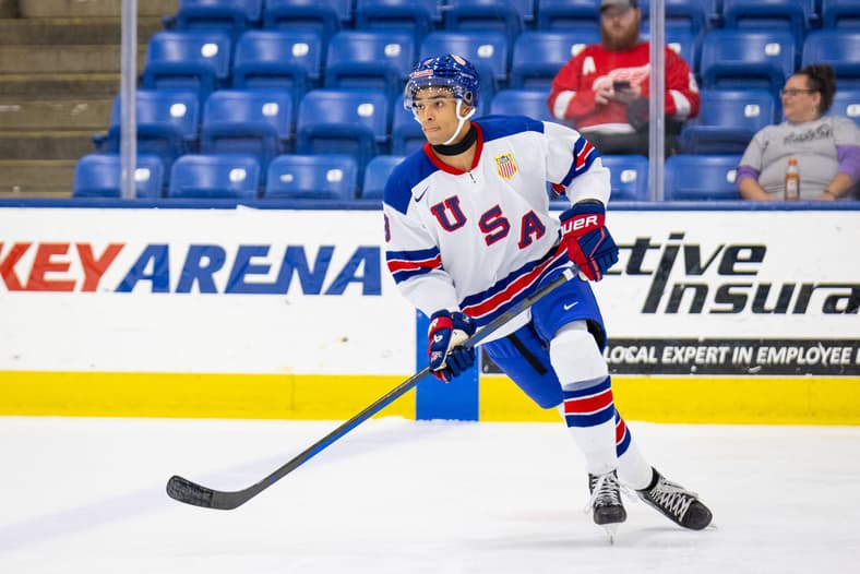 USA Hockey player wearing number 0 skating with hockey stick during game