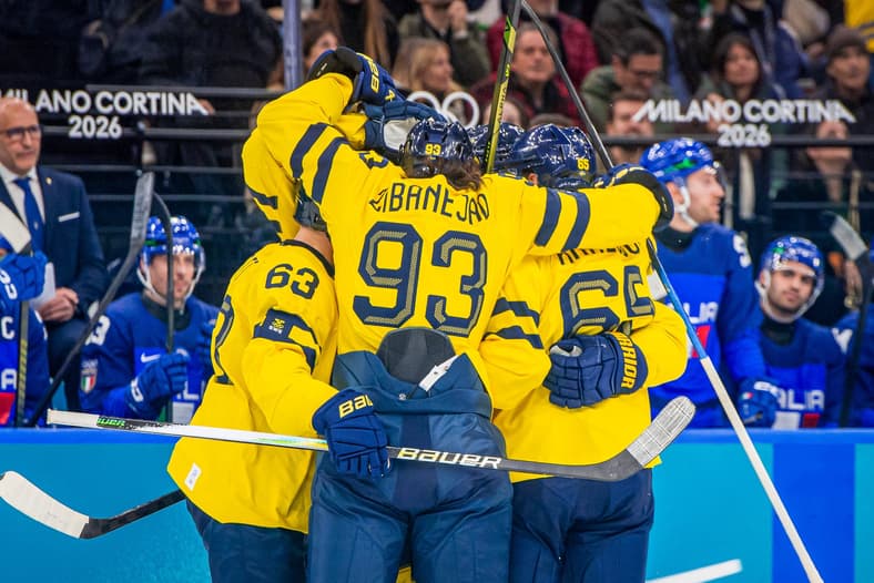 Swedish hockey players celebrate with sticks raised during Milano Cortina 2026 Olympic game