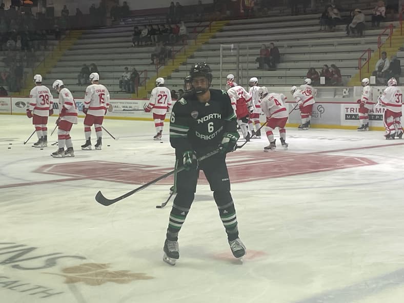 North Dakota hockey player number 6 during warm-ups before game against opponent in red jerseys
