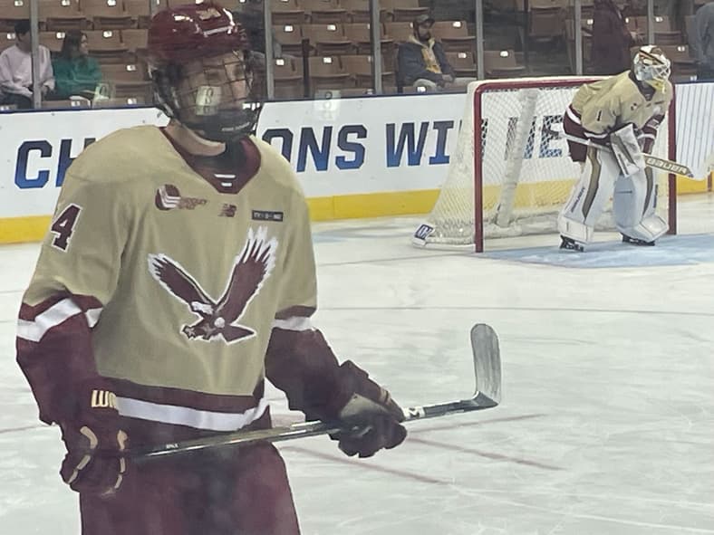 Boston College hockey player wearing number 4 in cream and maroon jersey during game