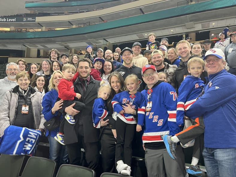 Large group of Rangers fans and players posing together at Madison Square Garden