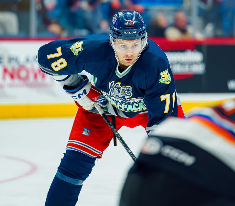 Hartford Wolf Pack player #18 skating with hockey stick during game